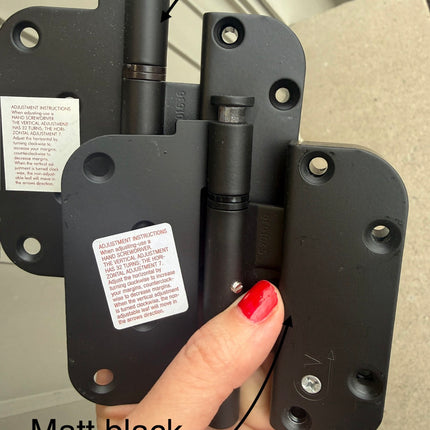 Two S4009 door hinges in hand. Showing color difference between Matt back (in front) and rustic umber (in back) 