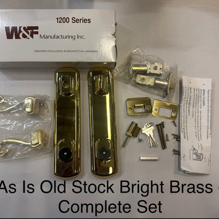 Complete set of old stock bright brass door hardware with W & F Manufacturing Inc. packaging. Handle set is bright brass with weather shield log on levers. 1200 series 6 inch center to center bore on a white background. Works on Hurd, weather shield and Peachtree doors 