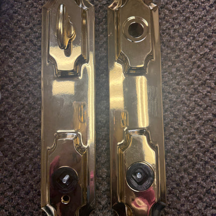 Pair of metallic door handles on a textured surface. W&F 1200 Series Handle Set 6" Center to Center Bore .Double Island Escutcheon Versailles Handles
